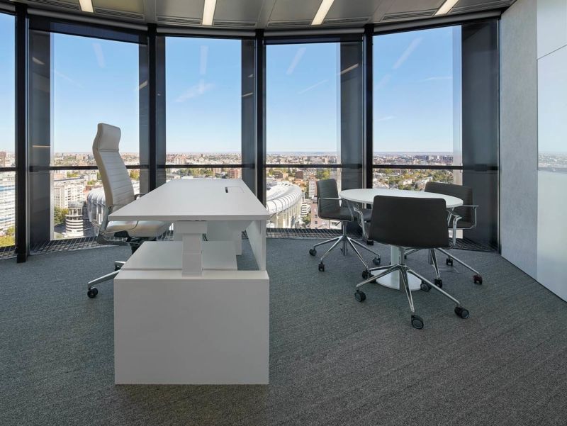 Mesa elevable blanca junto con mesa de reuniones redonda pequeña